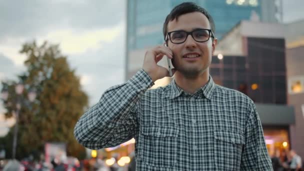 Медленный портрет красивого мужчины, говорящего по мобильному телефону на городской улице — стоковое видео
