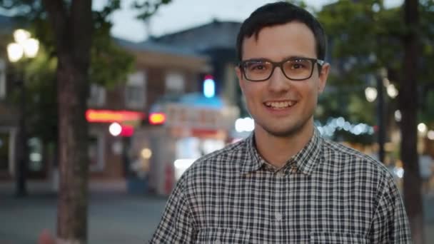 Movimiento lento de la persona amigable agitando la mano sonriendo al aire libre en la calle — Vídeos de Stock