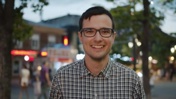 Πορτρέτο του όμορφου μαθητή σε γυαλιά γελώντας στο δρόμο της πόλης το βράδυ — Αρχείο Βίντεο