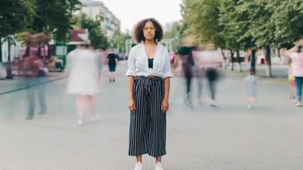 Zoom en lapso de tiempo de la mujer afroamericana seria en gafas al aire libre en la ciudad — Vídeos de Stock