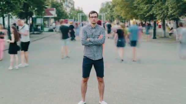 Zoom de lapso de tiempo de chico atractivo de pie en la calle de la ciudad con los brazos cruzados — Vídeo de stock