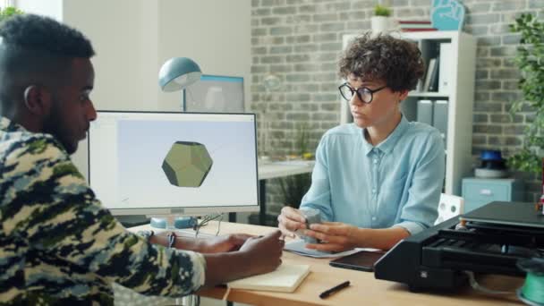 Kadın ve erkek ofiste konuşuyor. Plastik model tutmanın 3D baskısını tartışıyorlar. — Stok video