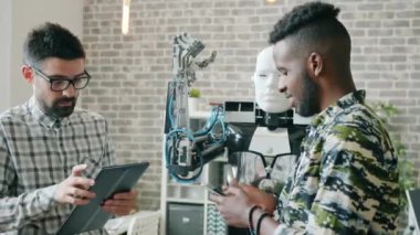 Modern laboratuvarda robotu çalıştırmak için tablet ve akıllı telefon kullanan mühendisler