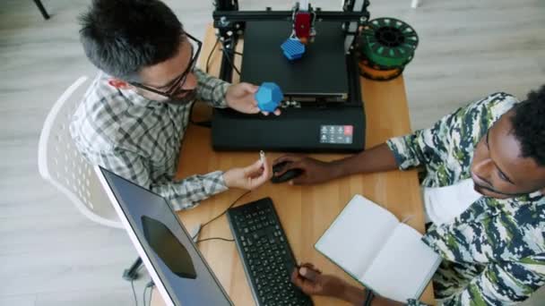 Ingénieurs joyeux fabrication détail imprimé 3d en utilisant l'ordinateur parlant dans le bureau — Video