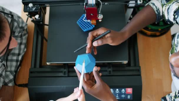 Дизайнеры мужского пола в 3D-форме обсуждают дизайн во время машинной печати — стоковое видео