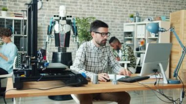 3D yazıcı ve bilgisayar kullanarak robot tasarımı yapan bir grup insan