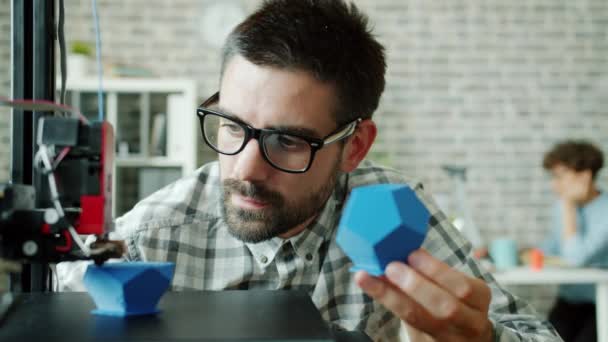 Homme chercheur regarder imprimante 3D faisant détail en plastique profiter du processus — Video