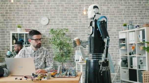 Rallentatore del robot futuristico che porta il caffè al giovane ricercatore in laboratorio — Video Stock