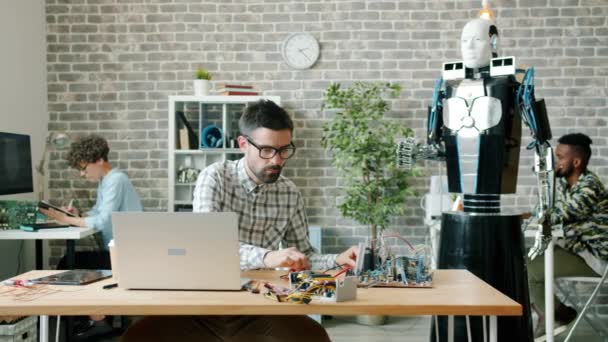 多种族创意团队利用计算机工作来设计办公室机器人。 人员、团队合作和现代技术概念. — 图库视频影像