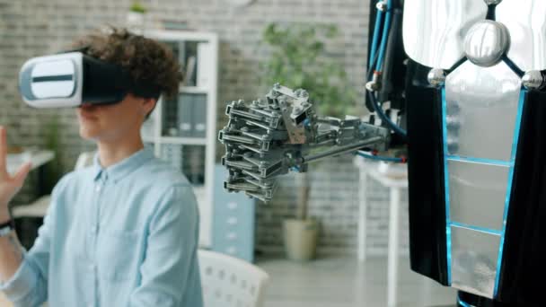 Slow motion of robotic arm moving like human when girl testing robot in office — Stock Video