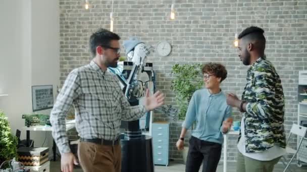 Smart robot dansen met een groep gelukkige ontwikkelaars op kantoor business party — Stockvideo