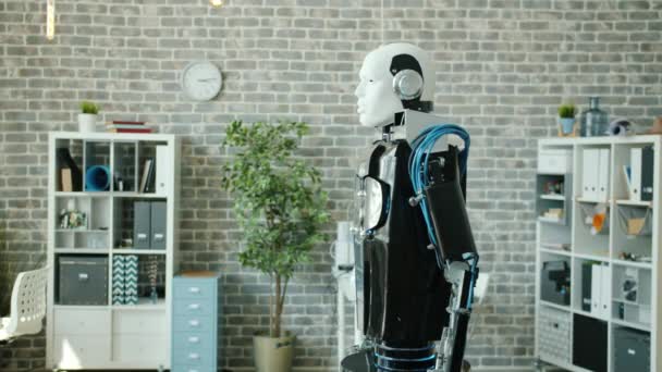 Retrato de robot inteligente rodando en la sala de oficina mirando la mano móvil de la cámara — Vídeos de Stock