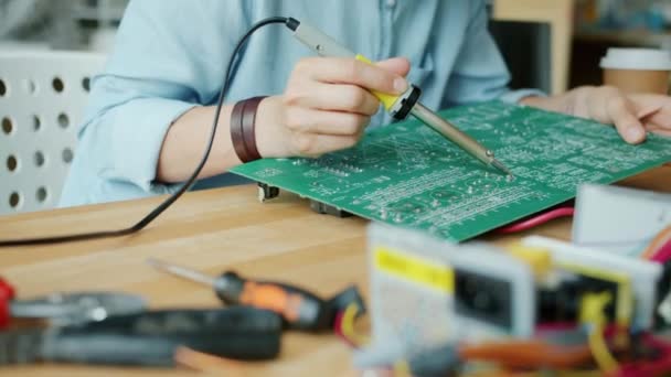 作業室でのハンダ付け鉄と女性の手固定マイクロ回路のスローモーション — ストック動画