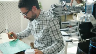 Erkek mühendis ofiste lehim demiriyle robot mikro devre kartını tamir ediyor.