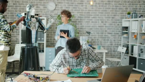 在办公室测试机器人和焊接主板的一群人 — 图库视频影像