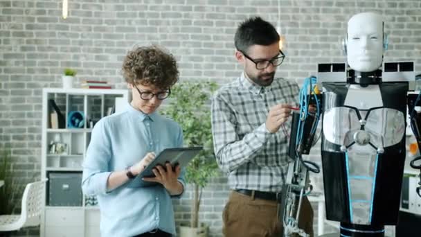 Mädchen und Jungen testen Roboterfunktionen mit modernen Geräten Tablet im Büro — Stockvideo