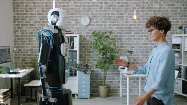 Modern ofisteki genç kadın geliştiricinin hareketlerini kopyalayan akıllı robot. — Stok video