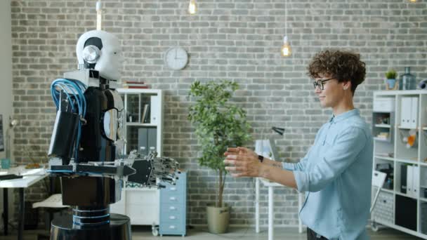 Leende kvinna som kontrollerar robottestsvar, maskinkopierande rörelser — Stockvideo