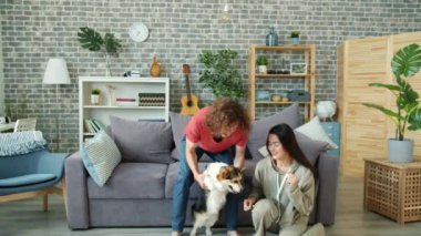 Karı koca Galli Corgi sosisliyle dans ediyor. Birlikte gülüyorlar.