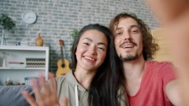 Evde kameraya bakarak konuşan sevimli bir çiftin portresi.