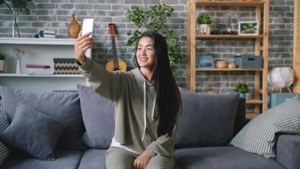 Slow motion av attraktiv asiatisk kvinna att göra videosamtal på nätet med hjälp av smartphone — Stockvideo