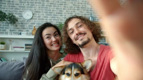 Punkt z szczęśliwy rodzina biorąc selfie z corgi pies pozowanie uśmiechnięty mając zabawy w domu — Wideo stockowe