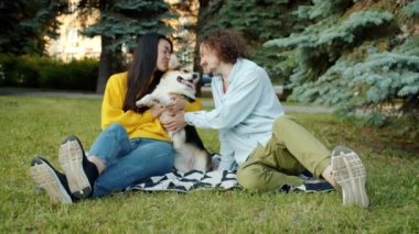 Genç adam ve kadın şehir parkında öpüşüp kucaklaşıyorlar.