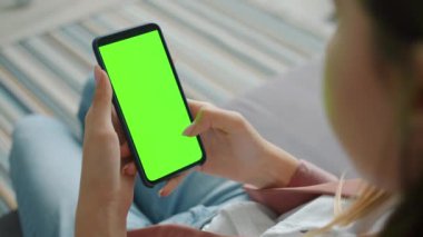 Evin içinde boş krom anahtar ekranlı akıllı telefon kullanan bir kadının yakın çekimi