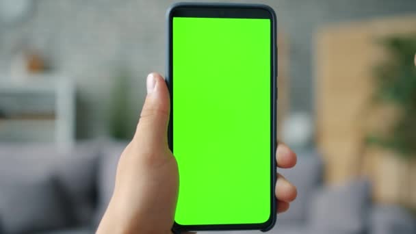 Detailní záběr mužské ruky drží chroma klíč zelená obrazovka smartphone v bytě — Stock video