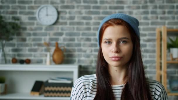 Portret van een serieuze vrouw begint te glimlachen en flirten kijkend naar camera binnen — Stockvideo