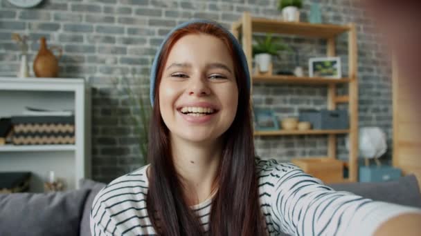 Retrato de una hermosa joven hablando haciendo videollamada desde casa haciendo gestos — Vídeo de stock