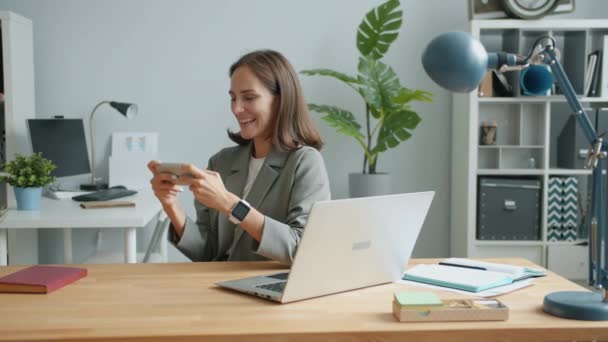 Zeitlupe von Mädchen beim Spielen mit Smartphone-Touchscreen im Büro — Stockvideo