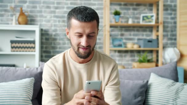Carefree středního věku chlap chatování online textové baví doma sám — Stock video