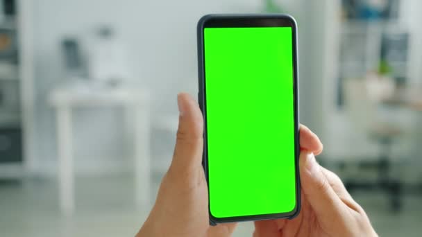 Σύγχρονο smartphone με πράσινη οθόνη στο ανδρικό χέρι σε εσωτερικό φόντο — Αρχείο Βίντεο