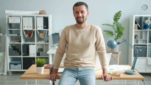 Slow motion portrait of charming man entrepreneur smiling in office room alone — ストック動画