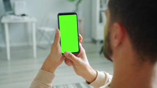 Movimento lento del maschio mano smartphone strisciamento con schermo verde toccare la navigazione — Video Stock
