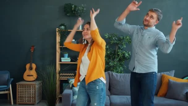 Χαρούμενο ζευγάρι που χορεύει στο σπίτι διασκεδάζοντας απολαμβάνοντας τον ελεύθερο χρόνο μαζί — Αρχείο Βίντεο