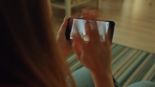 Медленное движение девушки, делающей видеозвонок со смартфона, глядя на экран гаджета — стоковое видео