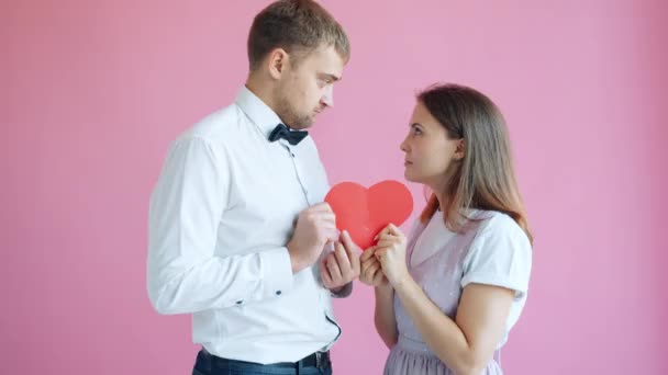 Mouvement lent du couple divisant la forme du cœur Valentine et marchant à part — Video