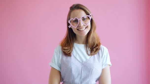 Retrato de alegre jovem senhora em forma de coração engraçado óculos sorrindo sentindo-se feliz — Vídeo de Stock