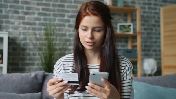 Joyful lady compras en línea pagando con teléfono inteligente y tarjeta bancaria sentirse feliz — Vídeo de stock