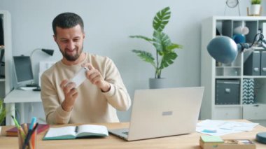 Ofis odasında gezici video oyunu oynayan neşeli orta yaşlı bir adam.