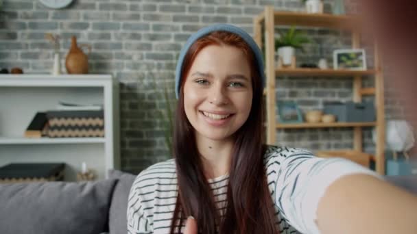 Chica alegre tomando selfie en casa usando sombrero mostrando pulgares arriba sonriendo — Vídeos de Stock