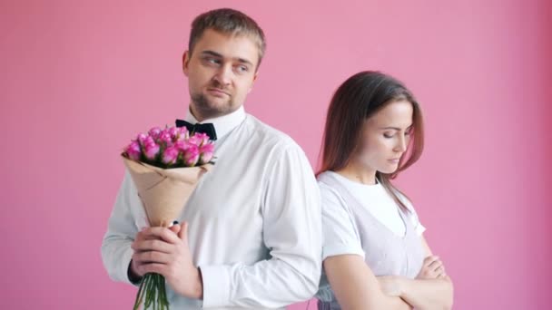 Sorgligt par står tillbaka till tillbaka då man ger blommor till flicka gör henne lycklig — Stockvideo