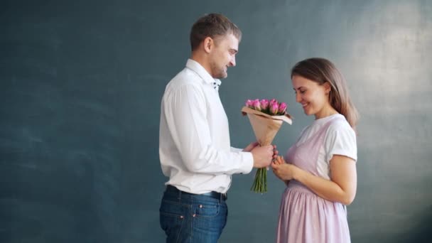 Chico cariñoso dando ramo de rosas a feliz esposa besándose en el día de San Valentín — Vídeos de Stock