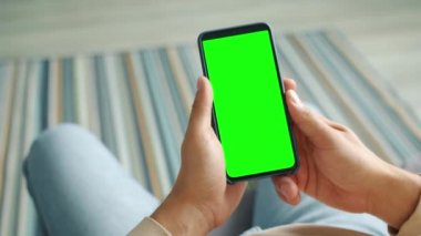 Çağdaş akıllı telefonu yeşil renkli ekranlı erkek eller tutuyor.