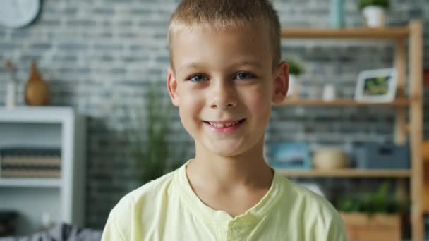 Close-up portret słodkie dziecko mały chłopiec uśmiecha się stojąc w mieszkaniu sam — Wideo stockowe