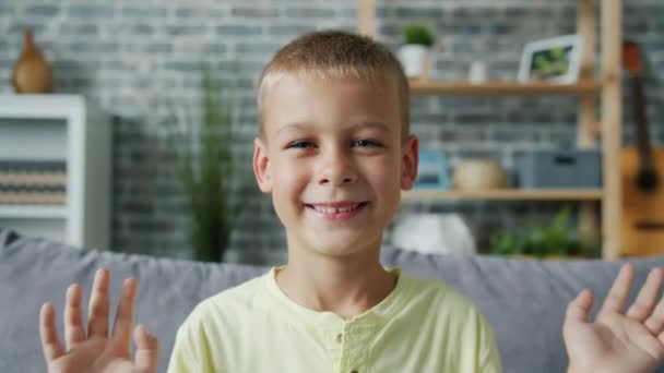 Портрет милого ребенка, играющего в прятки и ищущего закрытые глаза с улыбкой на руках — стоковое видео