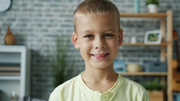Portret spowolniony ruch uroczy chłopiec z jasnymi włosami patrząc na aparat uśmiechnięty — Wideo stockowe
