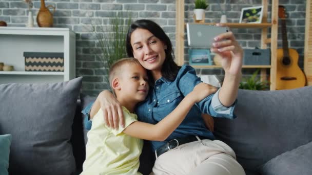 Mutlu anne ve oğul akıllı telefon kamerasına poz veriyor gülümsüyor ve selfie çekiyor. — Stok video